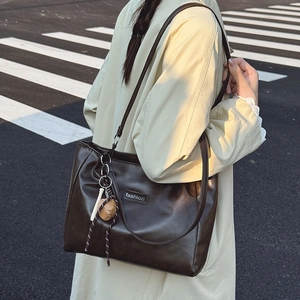 Large dark brown PU leather tote bag with fashion label and decorative charm for daily commute