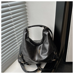 Detail of black faux leather Hobo bag featuring matte texture and golden hardware accents