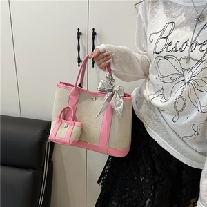 Fashionable beige canvas tote bag with pink leather trim and decorative silk scarf
