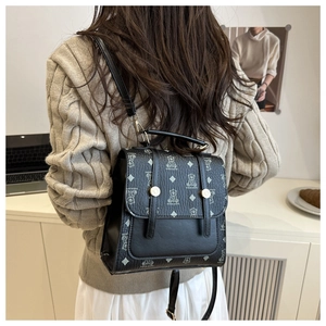 Detailed back view of a black leather polka dot backpack with metallic gold buckles