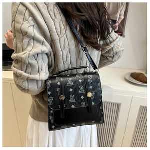 Detail of black polka dot crossbody bag with cartoon bear print on a textured surface