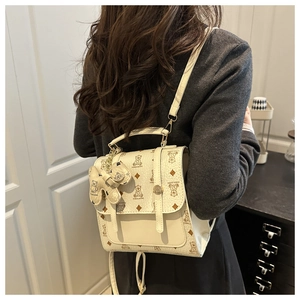 Detail of off-white backpack with cute bear patterns and textured leather finish
