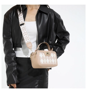 Detail van geblokte crossbodytas met jacquard riem en gouden metalen gesp
