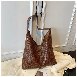 Détail du sac fourre-tout tressé marron foncé montrant la texture fine et le design hobo