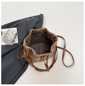 Dettaglio borsa a secchiello vintage in tweed a quadri con coulisse in pelle e fodera