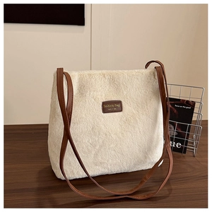 Gros plan sur un sac cabas en fausse fourrure beige avec des lanières en cuir marron
