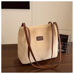 Détail du sac fourre-tout en peluche beige montrant la texture douce et l'étiquette