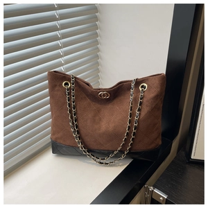 Detalle del bolso tote a cuadros con herrajes dorados y diseño de patchwork de gamuza