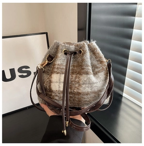 Dettaglio borsa a secchiello in lana scozzese grigio-marrone con finiture dorate