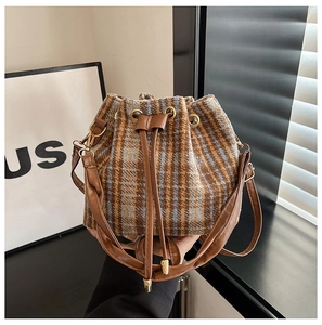 Dettaglio borsa a secchiello vintage in tweed con coulisse in pelle marrone e finiture oro