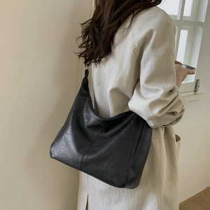 Vista posteriore dettagliata di una grande borsa tote in ecopelle nera su una modella