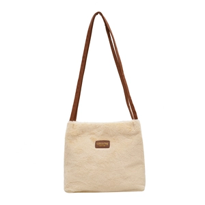Sac seau en peluche crème avec bandoulières marron et écusson mode pour l'hiver