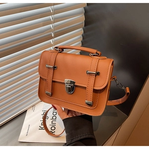 Détail du sac bandoulière en cuir PU marron avec boucle en métal et texture vintage rétro