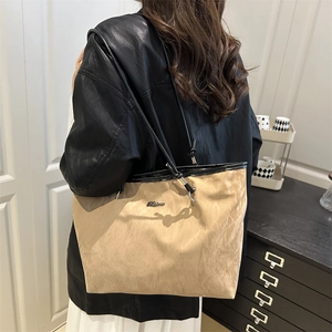 Minimalist khaki textured tote bag with black trim and leather straps for daily commute