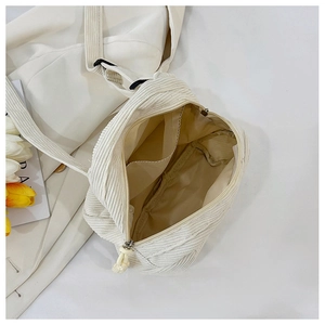 Detailed interior of a beige corduroy shell bag with metal zipper and inner pocket