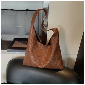 Dettaglio della trama intrecciata marrone della grande borsa hobo con tracolla larga