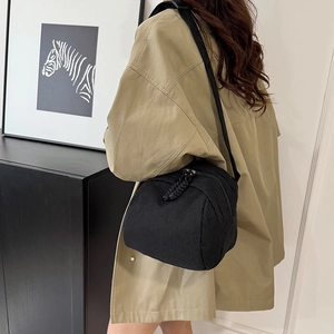 Fashionable black corduroy crossbody bag for women with a stylish wide strap on a model