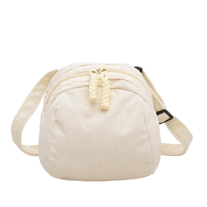 Minimalist cream corduroy crossbody bag with dual braided zipper pulls and adjustable strap