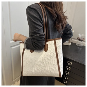 Close-up of white woven tote bag with brown straps and spacious interior detail