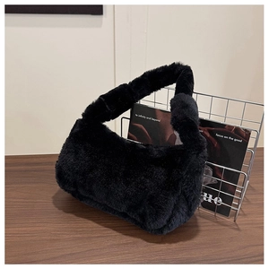 Vue détaillée de la texture douce en fausse fourrure noire sur un sac à main en peluche