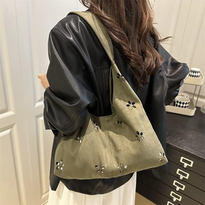Borsa tote verde in maglia con intagli floreali e paillettes portata sulla spalla