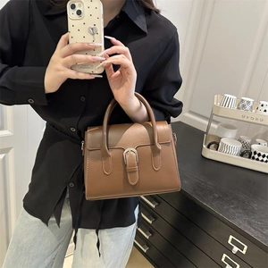 Chic brown leather mini handbag with silver horseshoe buckle in modern interior setting