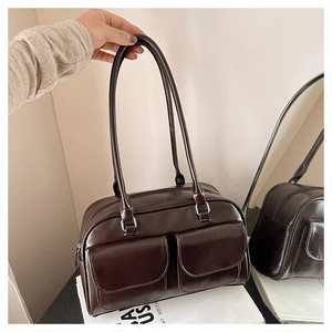 Détail du sac sous le bras marron vintage avec deux poches à rabat et fines bandoulières