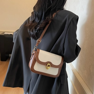Chic two-tone crossbody bag with gold twist lock and adjustable brown leather shoulder strap