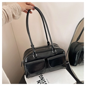 Détail du sac sous le bras noir brillant avec doubles poches à rabat et boucles argentées