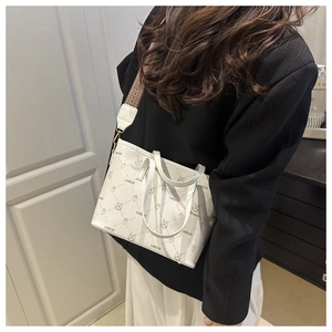 Detailed shot of white tote bag with bear jacquard and stylish herringbone canvas strap