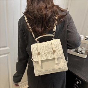 Mini sac à dos beige chic pour femme avec texture tissée et boucle en métal doré