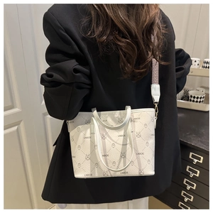 Close-up of white bear jacquard tote bag with stylish wide woven strap and leather texture