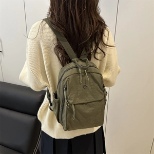Sac à dos en nylon vert armée avec poches et logo 'M' porté par un mannequin