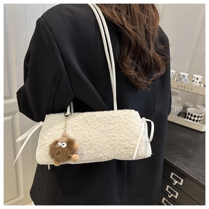 Detail view of white fleece mini crossbody bag with cute doll charm and bow accents