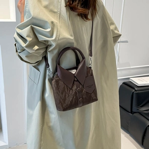 Sac à main en cuir marron en forme de chemise avec boutons vintage porté par un modèle