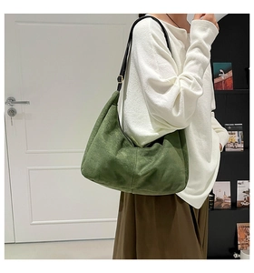 Detalle del bolso hobo de ante verde oscuro mate con correa ajustable de cuero negro