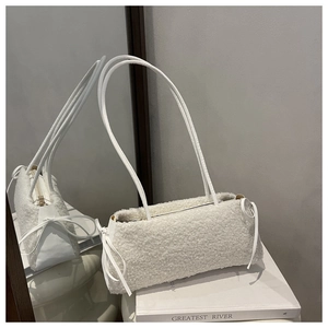 Close-up of white faux fur mini shoulder bag with elegant ribbon bows and metal zipper