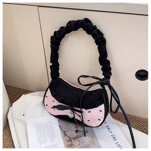 Detail of contrast color pink shoulder bag with large black bow and heart pendant