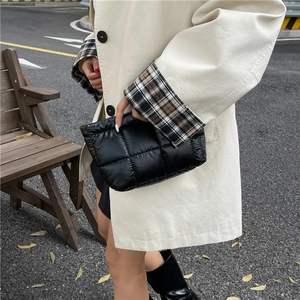 Chic black quilted puffy clutch bag for women featuring minimalist down-filled design