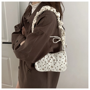Dettaglio borsa a spalla in velluto a coste bianco con stampe di cuori e tracolla arricciata