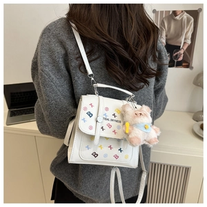 Détail d'un sac à dos blanc en cuir PU avec motif de lettres colorées et porte-clés ours