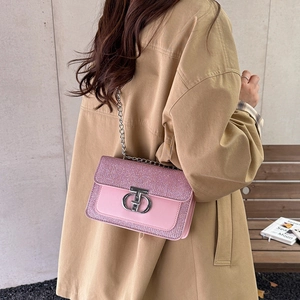 Pink chain crossbody bag with metal buckle shown on model wearing trench coat