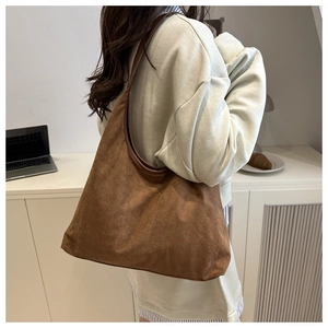 Caramel suede tote bag detail showing wide shoulder strap and matte leather texture
