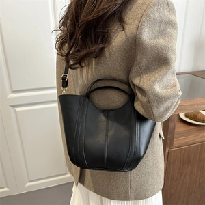 Chic black leather mini bucket bag with decorative stitching and detachable shoulder strap