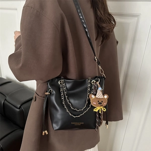 Sac seau tendance en cuir noir mat avec chaîne dorée et pendentif ours brun détachable