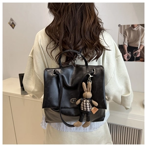 Rückansicht eines schwarzen Lederrucksacks mit süßem Kaninchen-Anhänger und Silberschnalle