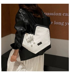 Detail of white corduroy tote bag with black trim and a cute cloud charm accessory