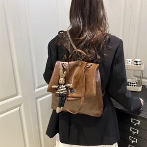 Vintage brauner PU-Lederrucksack mit süßem Hasenanhänger am minimalistischen Modell