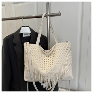 Detailed macro view of beige woven tassel tote bag with intricate V-shape crochet patterns