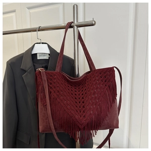 Detail of burgundy tote bag with hand-woven fringe tassels and leopard print texture
